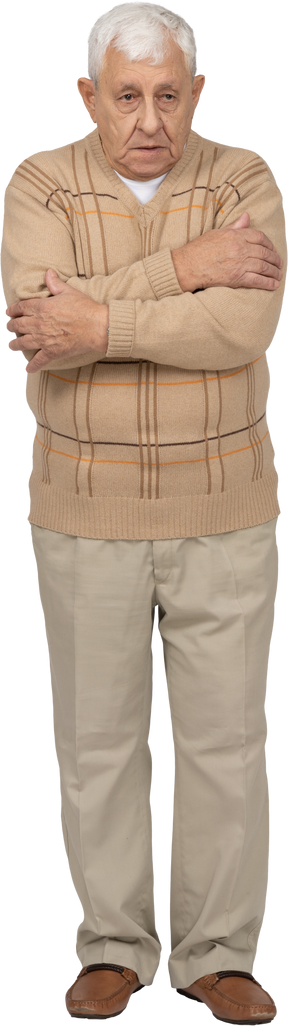 Front view of an old man in casual clothes hugging himself