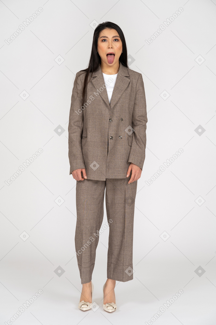 舌を示す茶色のビジネススーツの若い女性の正面図