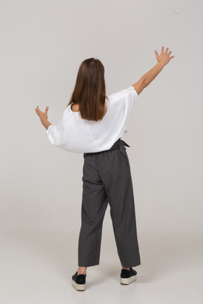 Vista posterior de una joven en ropa de oficina que muestra el tamaño de algo