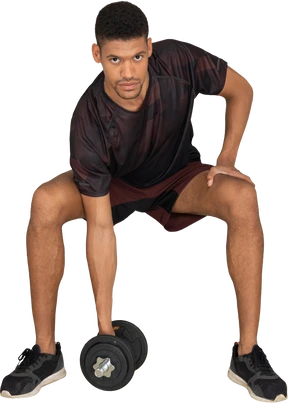 Young man in sports clothes lifting weigths
