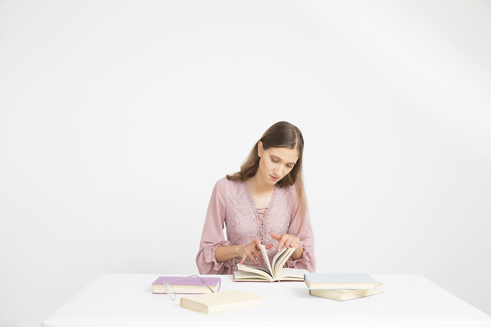 Young girl sitting at the table and flipping through pages