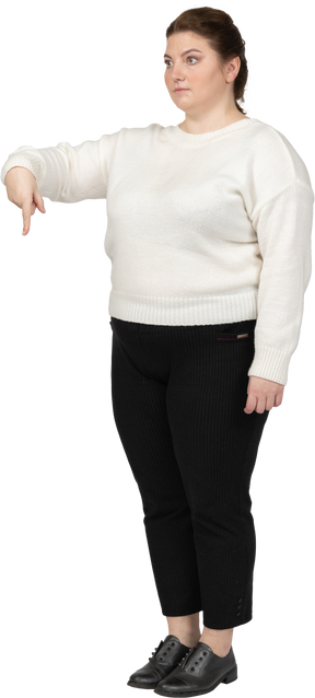 Plus size woman in casual clothes pointing down with a finger