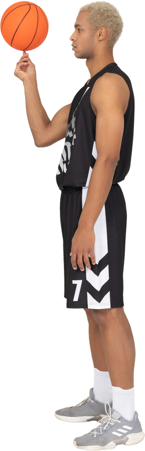 Трехчетвертный вид сзади молодого баскетболиста, держащего мяч