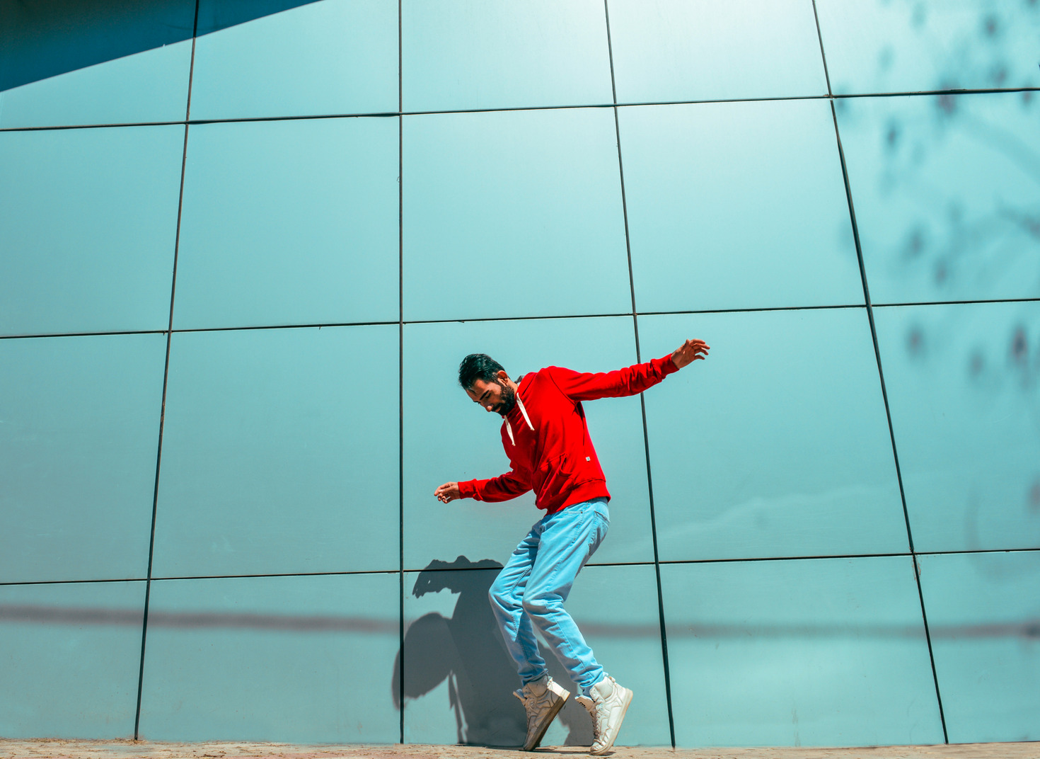 Young man dancing in front of a wall