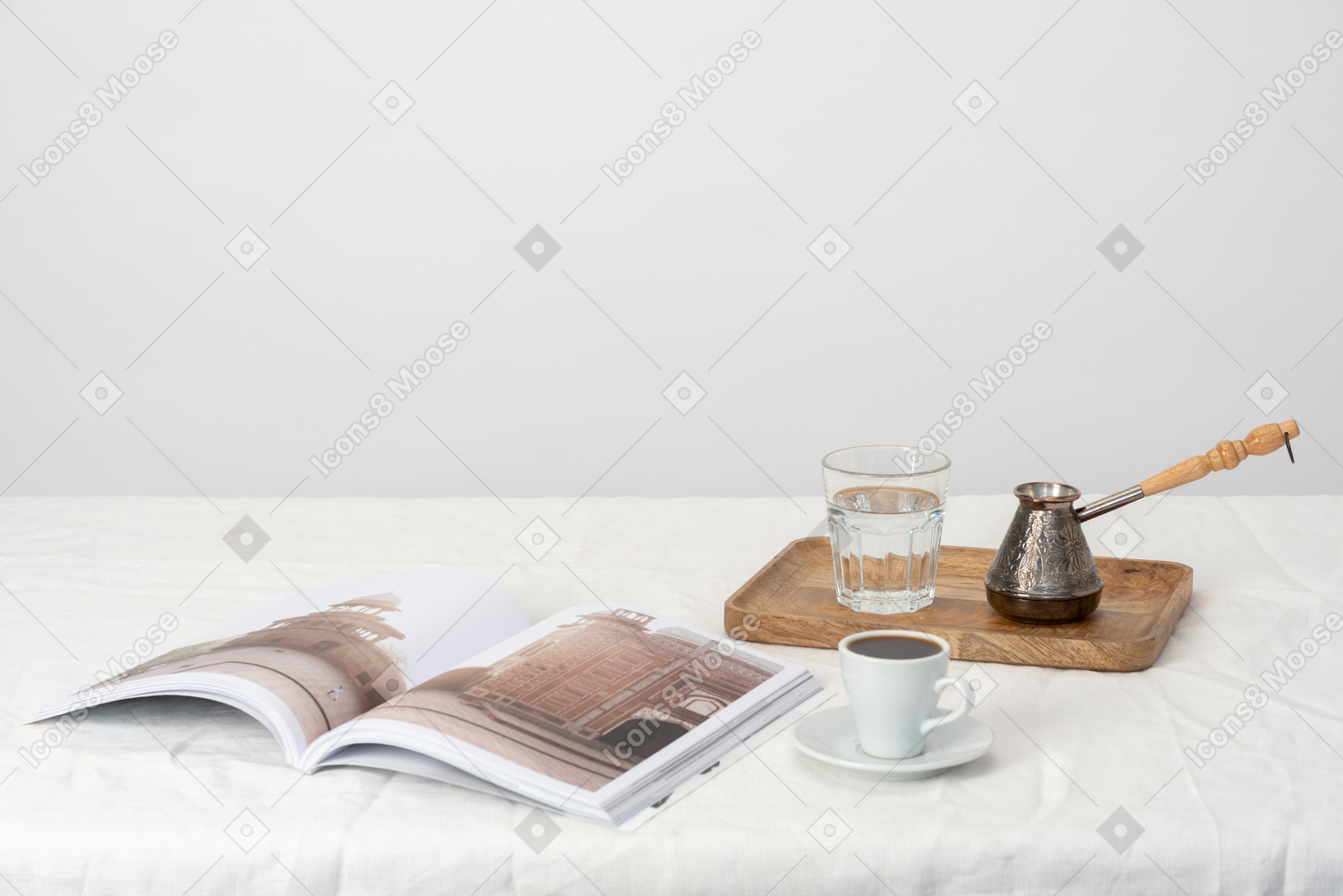 Cezve and glass of water on the tray, magazine and cup of coffee