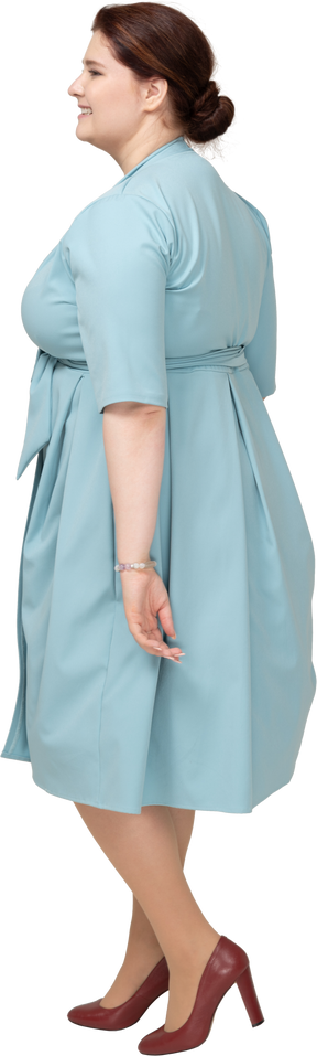 青いドレスを歩いている女性の側面図