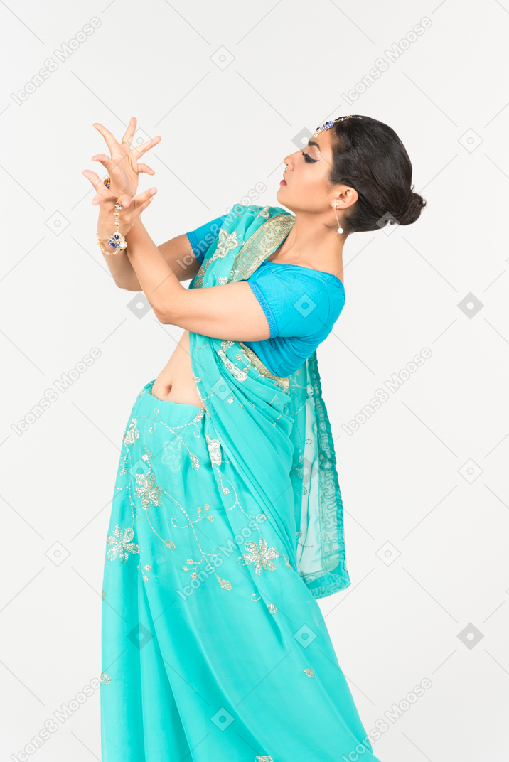 Jeune femme indienne en sari bleu debout en position de danse