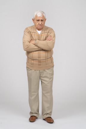 Vista frontal de un anciano con ropa informal de pie con los brazos cruzados y mirando a la cámara