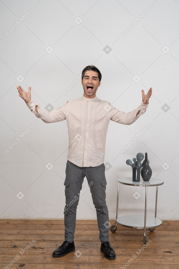 Front view of a happy man in casual clothes gesturing