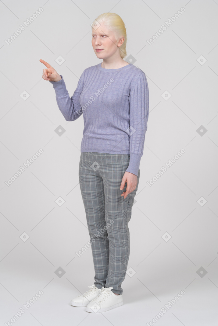 Mujer joven señalando con el dedo