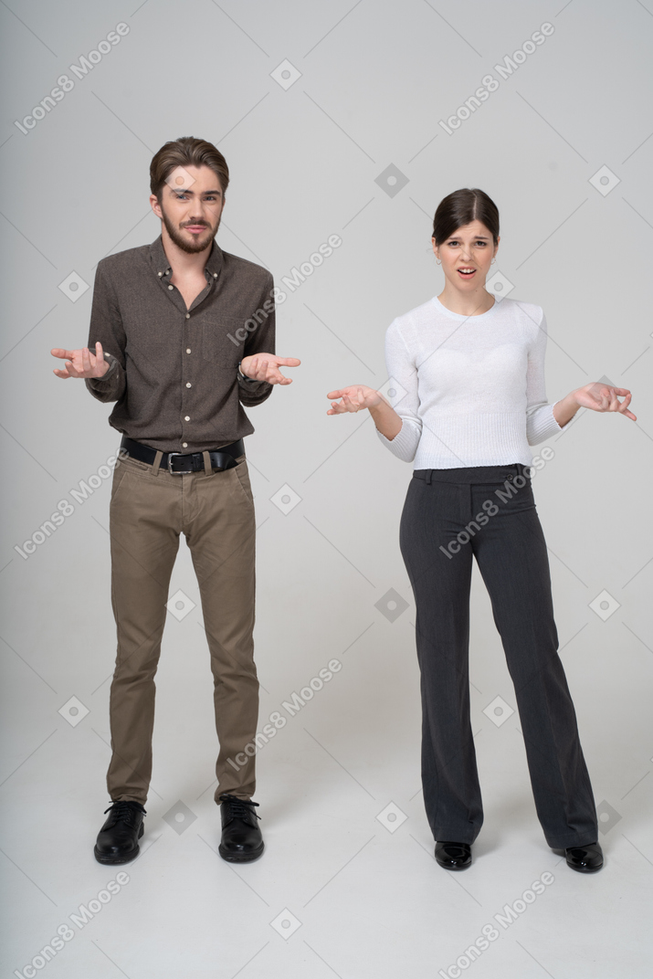 Vista frontal de um jovem casal questionando em roupas de escritório