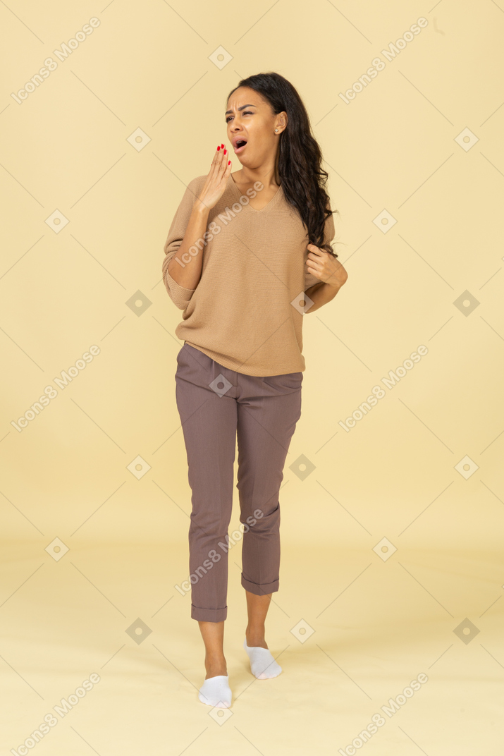あくびをする浅黒い肌の若い女性の隠れた口の正面図
