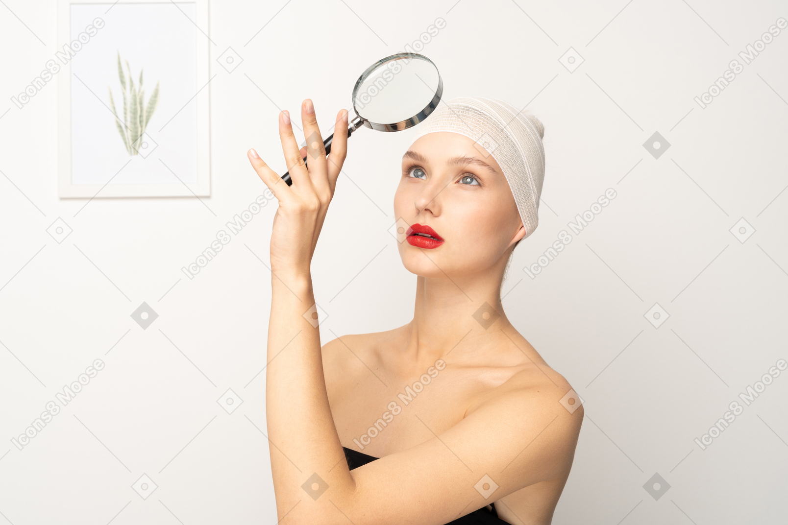 Portrait of a young woman holding up magnifying glass