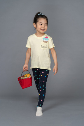 Little girl going grocery shopping with a basket