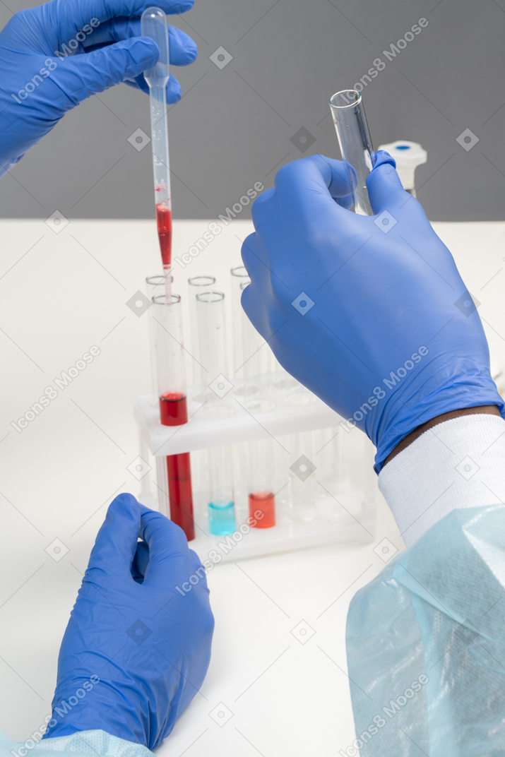 Hands in gloves working with medical tubes