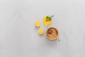 Bol de miel, citrons et jus de citron avec des feuilles de romarin