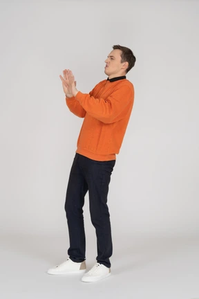 Young man in orange sweatshirt standing