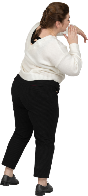 Rear view of a plump woman in casual clothes gesturing