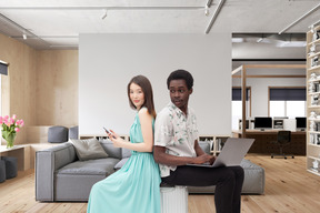 A man and a woman sitting on a couch in a living room