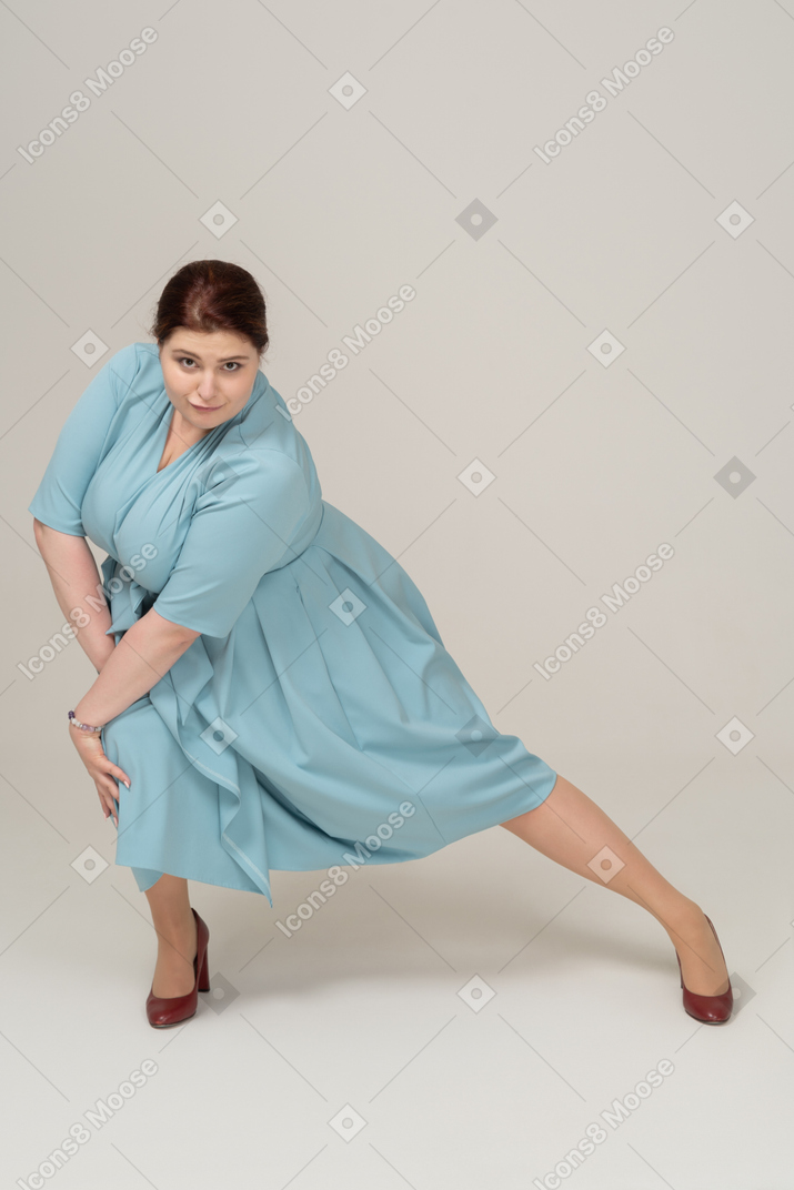 Front view of a woman in blue dress exercising