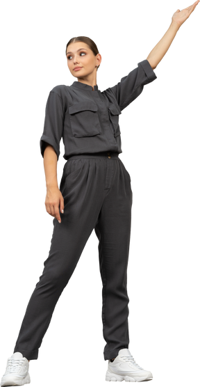 Front view of a young woman in a jumpsuit outstretching her arm