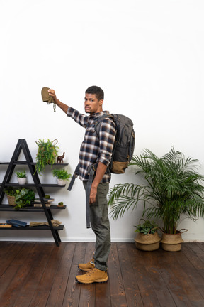 Side view of a thirsty tourist holding an empty flask