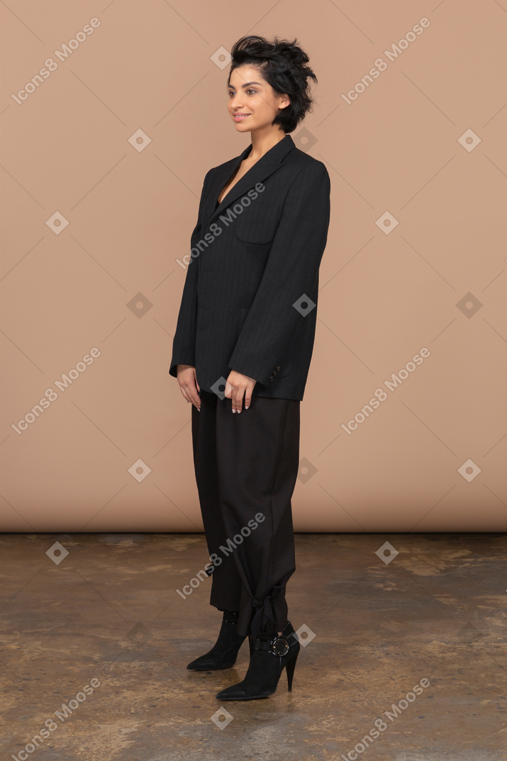 Vista de tres cuartos de una empresaria vistiendo traje negro y sonriendo