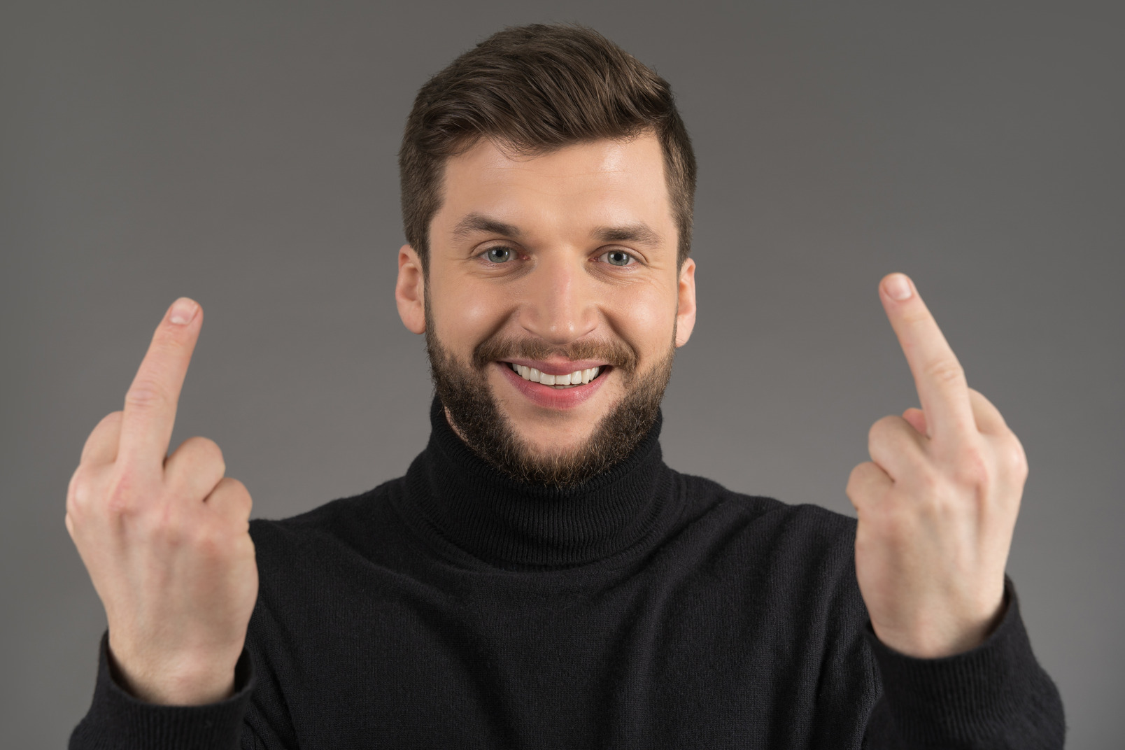 Delighted man making a rude gesture with middle fingers