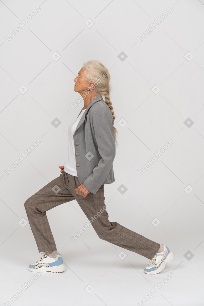 一位穿着西装做瑜伽的老妇人的侧视图