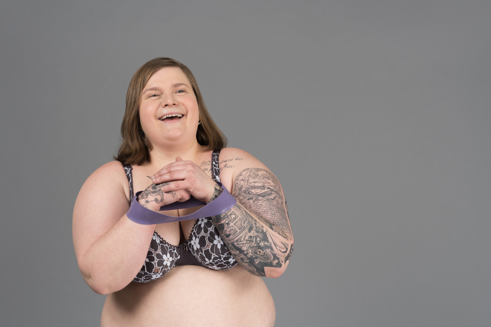 Plump laughing woman holding gymnastic rubber ring