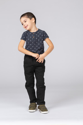 Vista frontal de um menino feliz em roupas casuais olhando para o lado