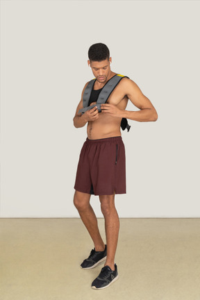A three-quarter side view of the muscular man wearing a life vest and looking down
