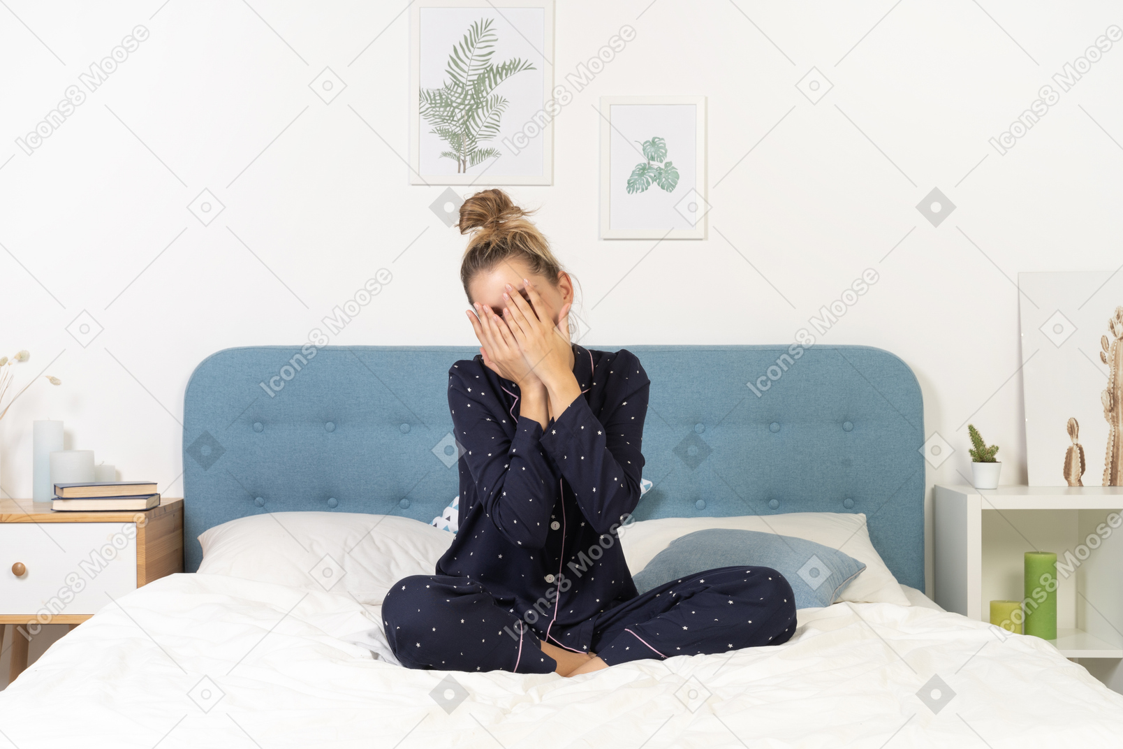 Front view of a young woman in pajamas staying in bed and hiding face