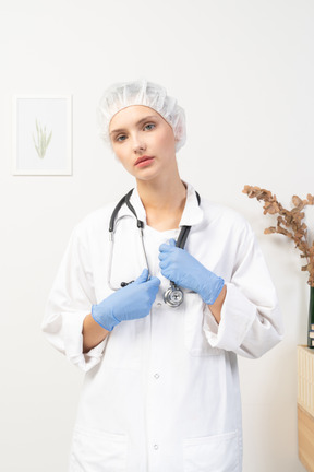 Vista frontal de una joven doctora sosteniendo estetoscopio