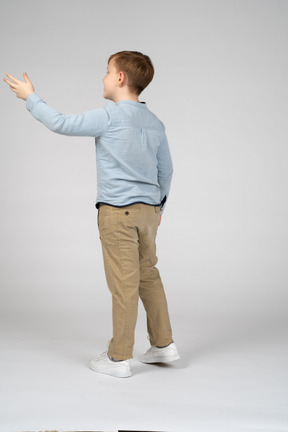 Back view of a boy waving