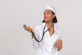 Atractivo joven doctora sosteniendo un estetoscopio