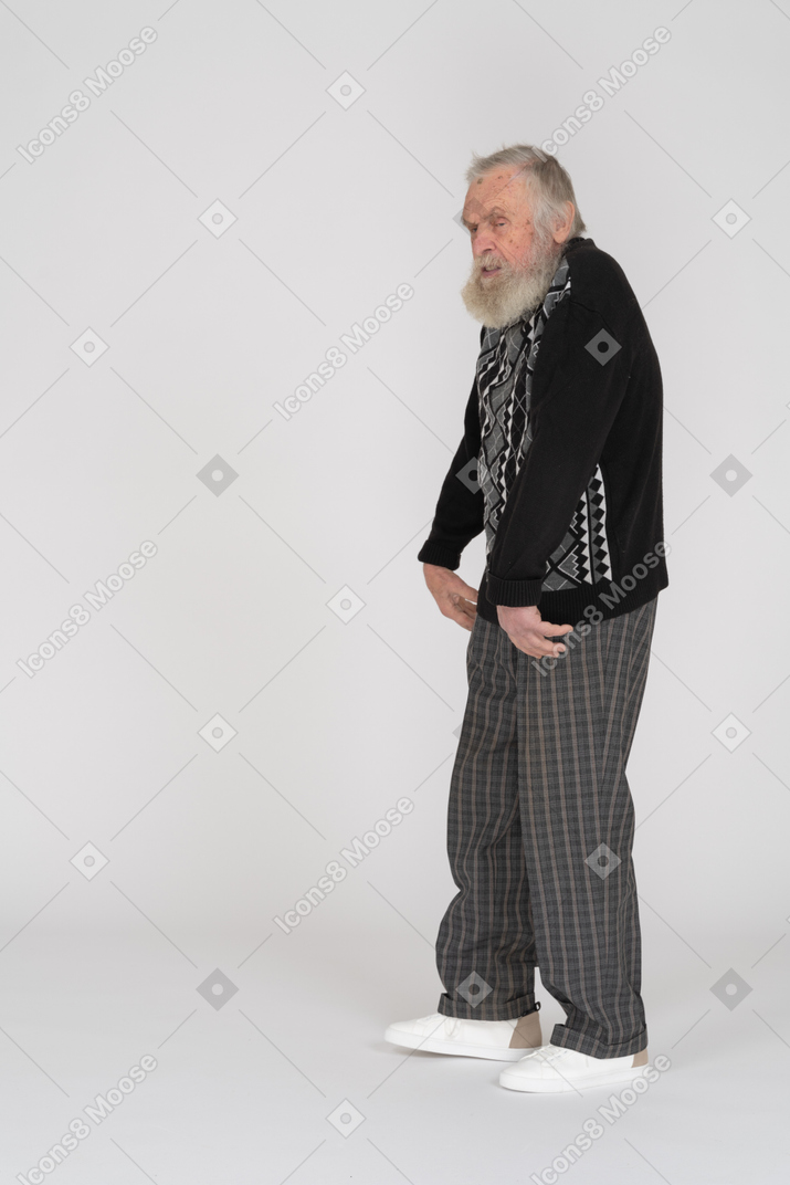 Side view of an old man standing and flexing his wrists