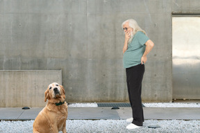 A man covering his mouth next to a dog