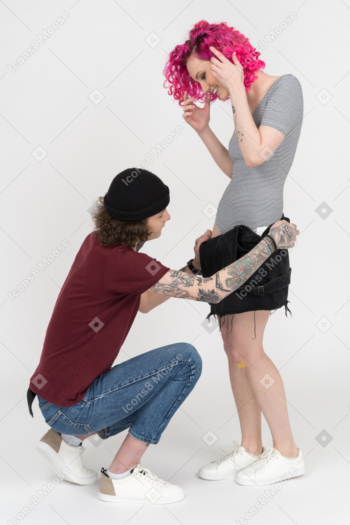 Женщина с красивой обнаженной девочкой-сапожкой снимает платье