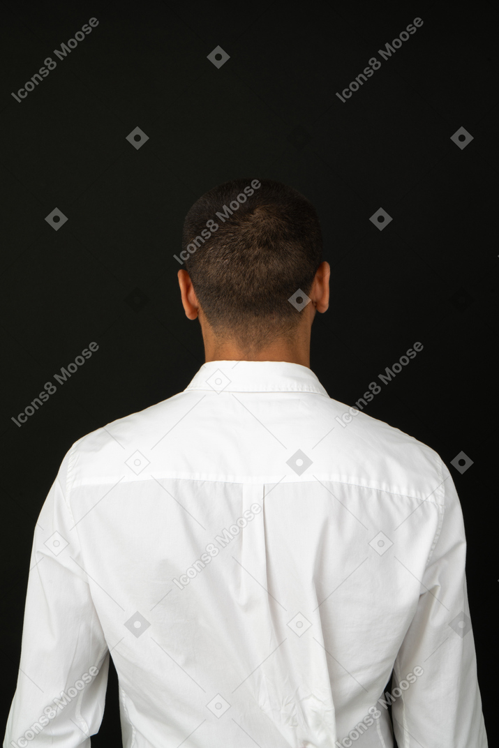 Vista posterior de un joven en camisa blanca
