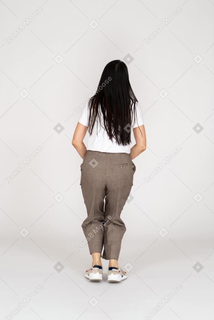 Back view of a squatting young woman in breeches