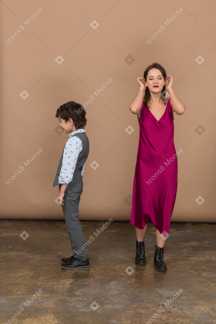 Niño de perfil y mujer tocándose el pelo