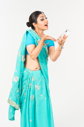 Jeune danseuse indienne détenant smartphone