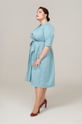 Вид спереди женщины в голубом платье, смотрящей вверх