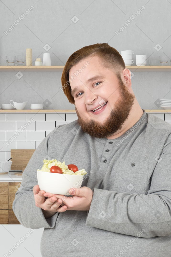 A man with a beard holding a bowl of food