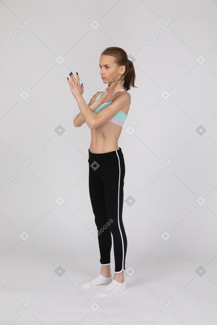 Chica adolescente en ropa deportiva haciendo gesto de parada