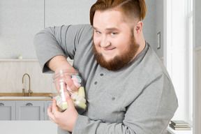 A man with a beard holding a jar of candy