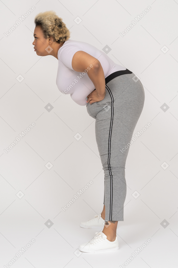 Plus size dark skinned female bending forward with her arms akimbo
