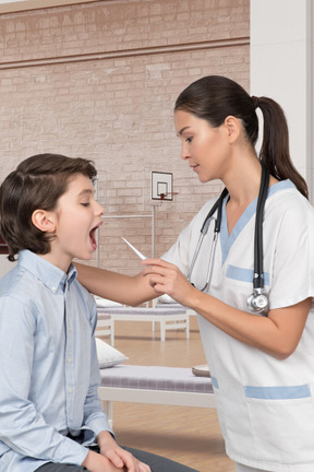 A young boy is being examined by a nurse