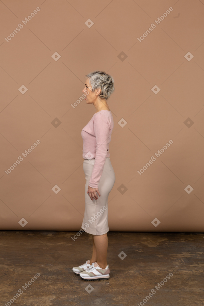 Вид сбоку на женщину в повседневной одежде, стоящую с открытым ртом